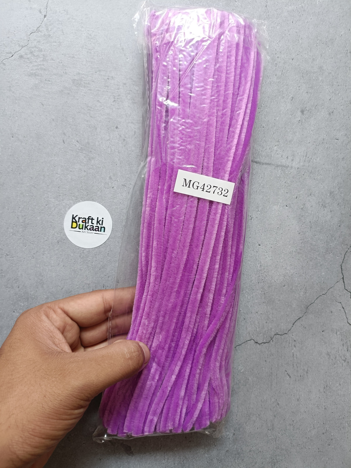Light purple pipe cleaners in a clear plastic pack, hand-held bundle with label tag