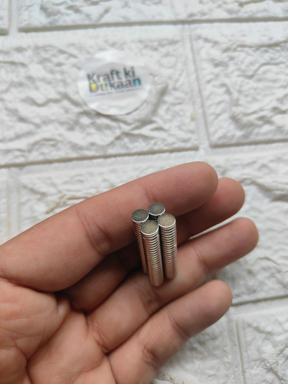 Silver round steel magnets, small disc magnets held in open hand