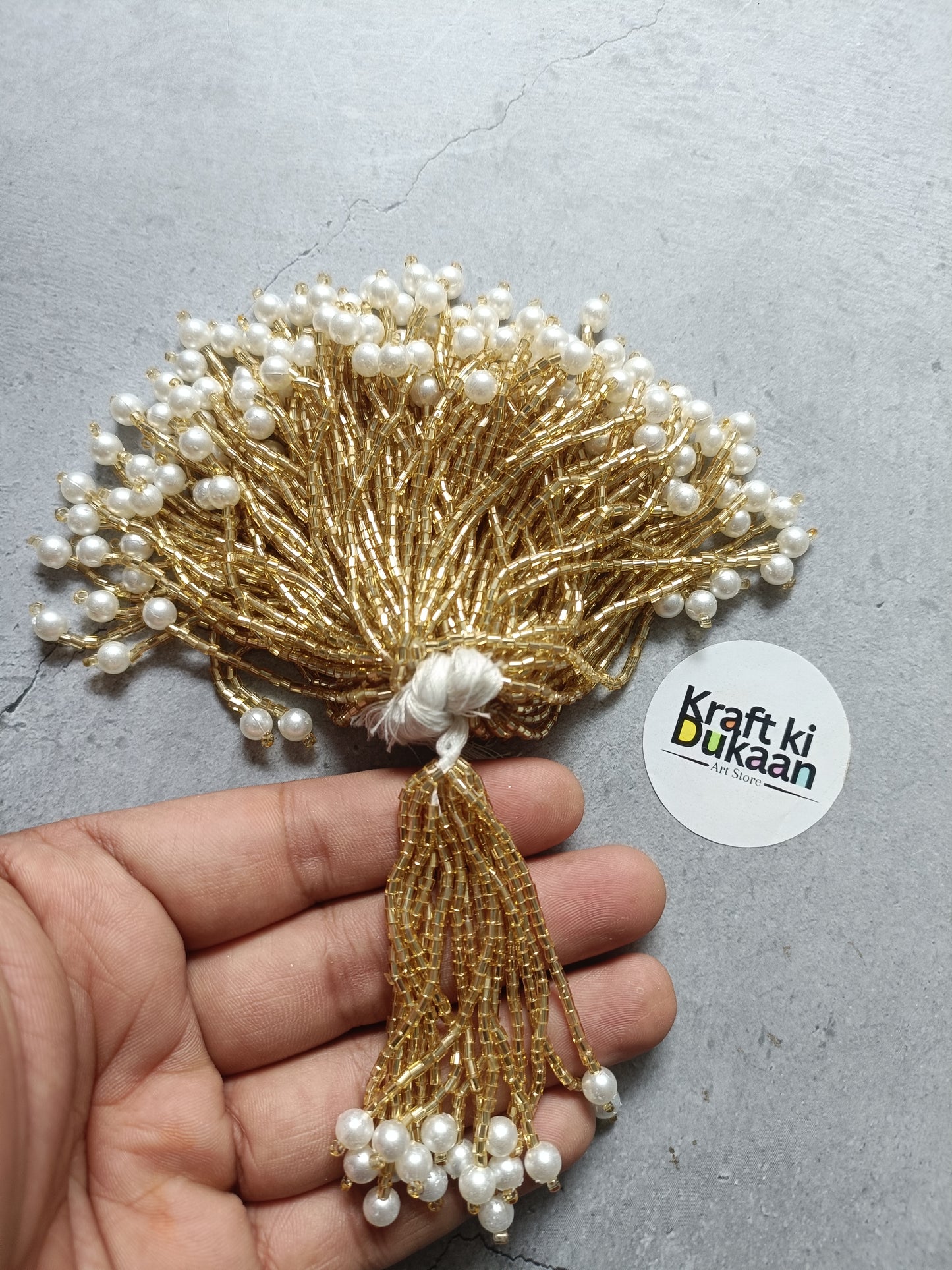 Gold pearl tassel embellishment with white bead fringe and wire bundle