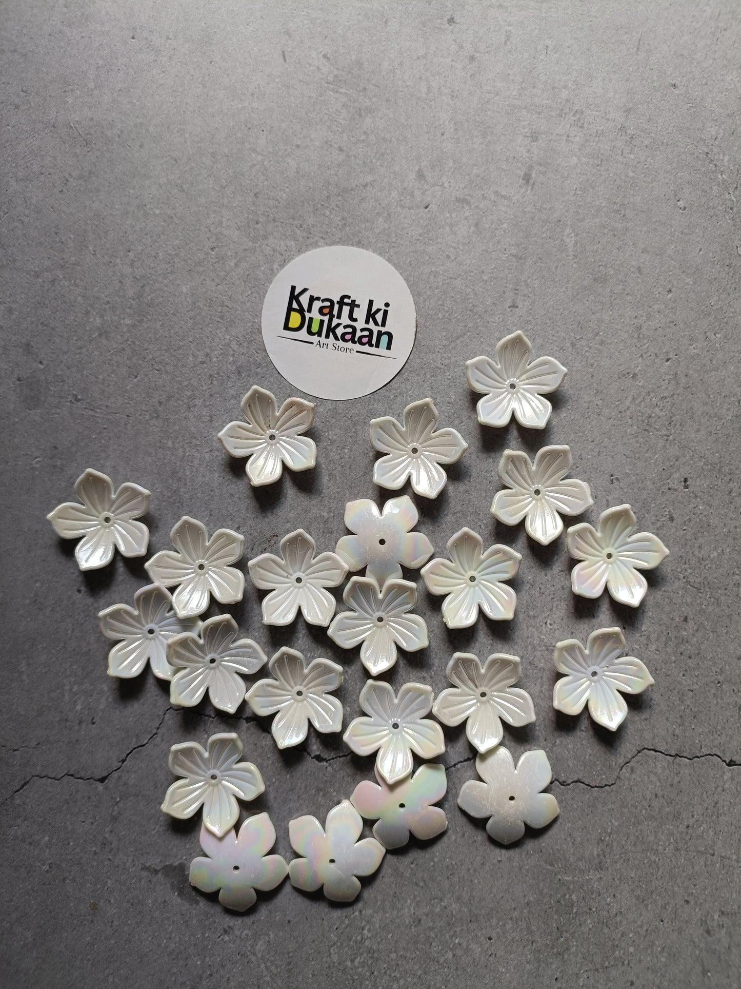 White five-petal flower beads scattered on surface