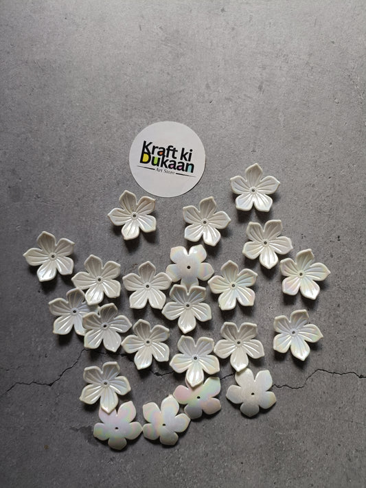 White five-petal flower beads scattered on surface