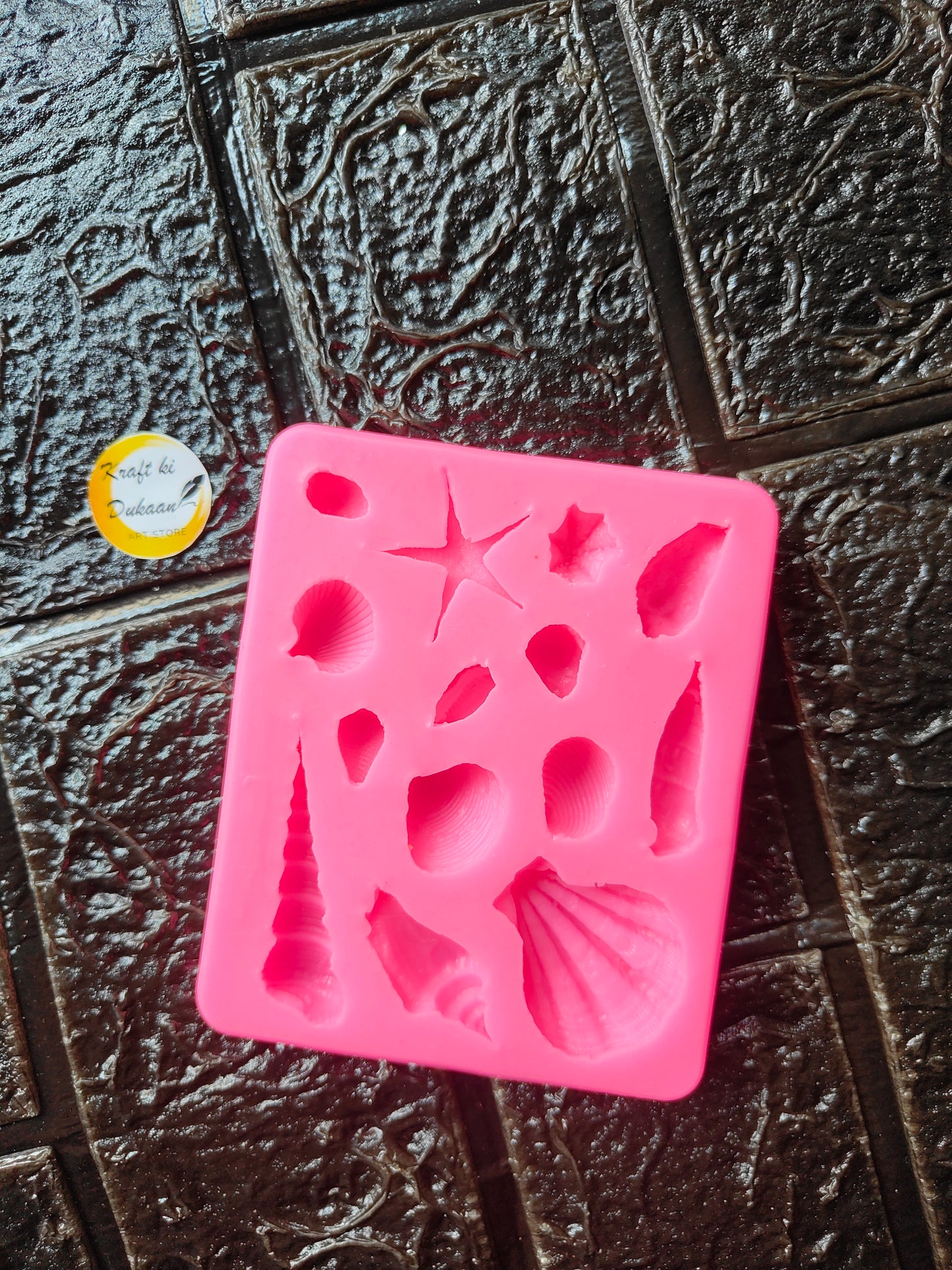Pink silicone seashell mold with 14 cavities and raised shell shapes