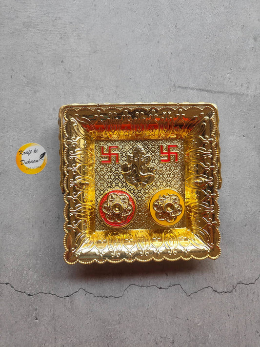 Decorative gold roli chawal plate for pooja with intricate design and vibrant colors