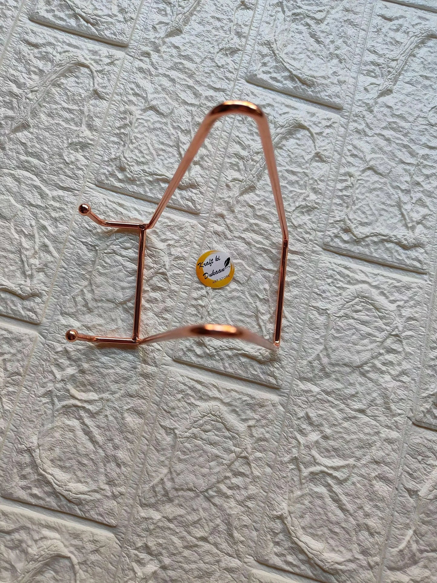 Rose gold metal stand with arched top and two horizontal supports, rose-gold