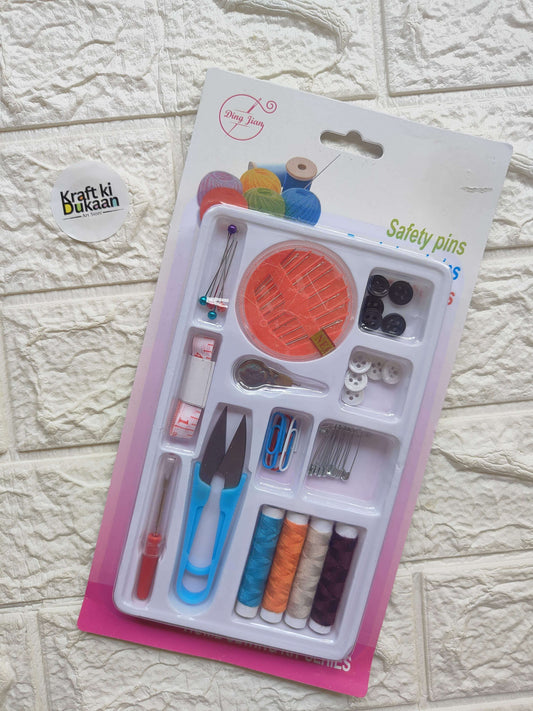 Sewing kit blister pack with safety pins, multiple thread spools, needles, and scissors