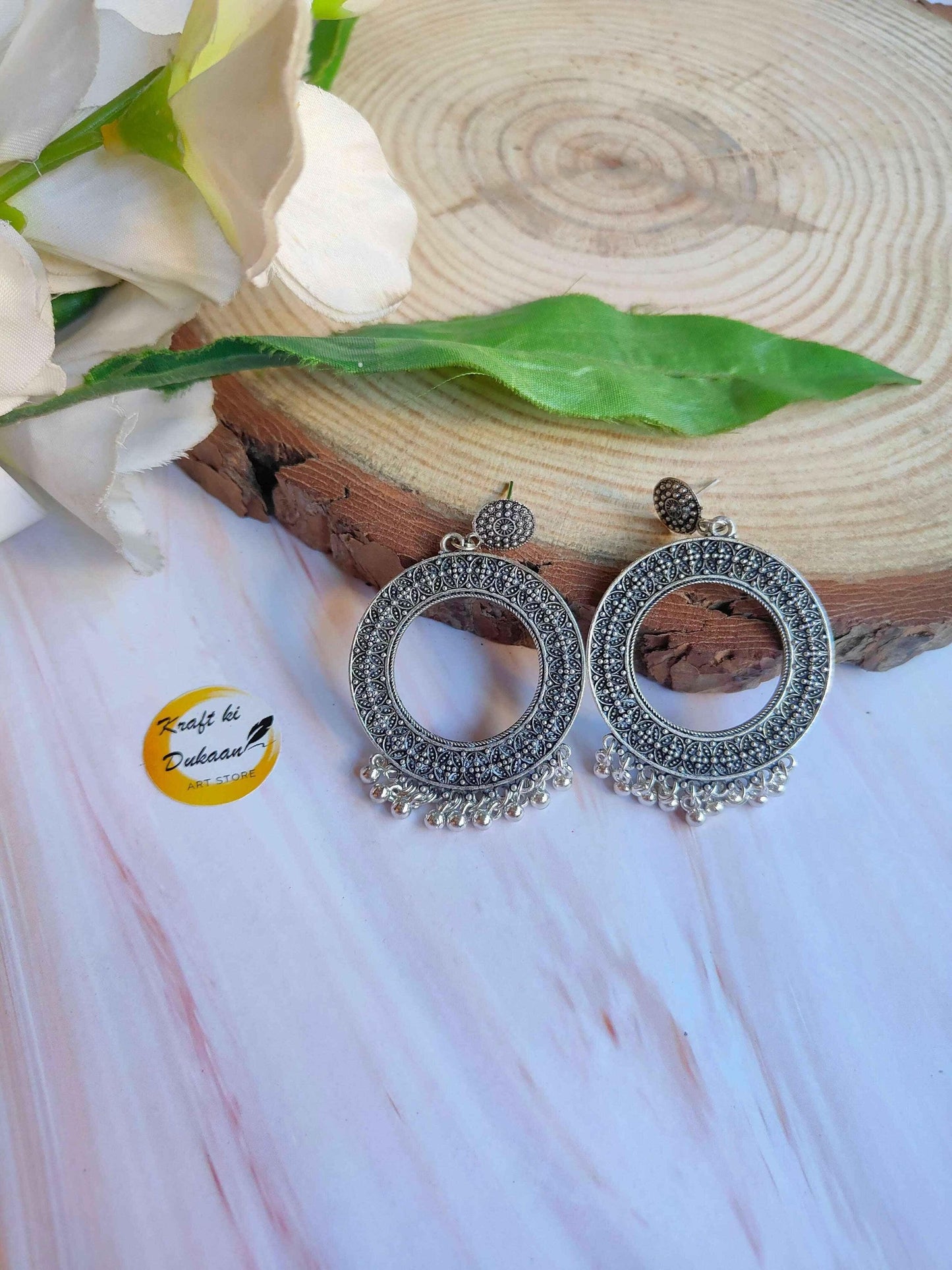 Silver jhumka earrings with intricate round filigree and small dangling fringe