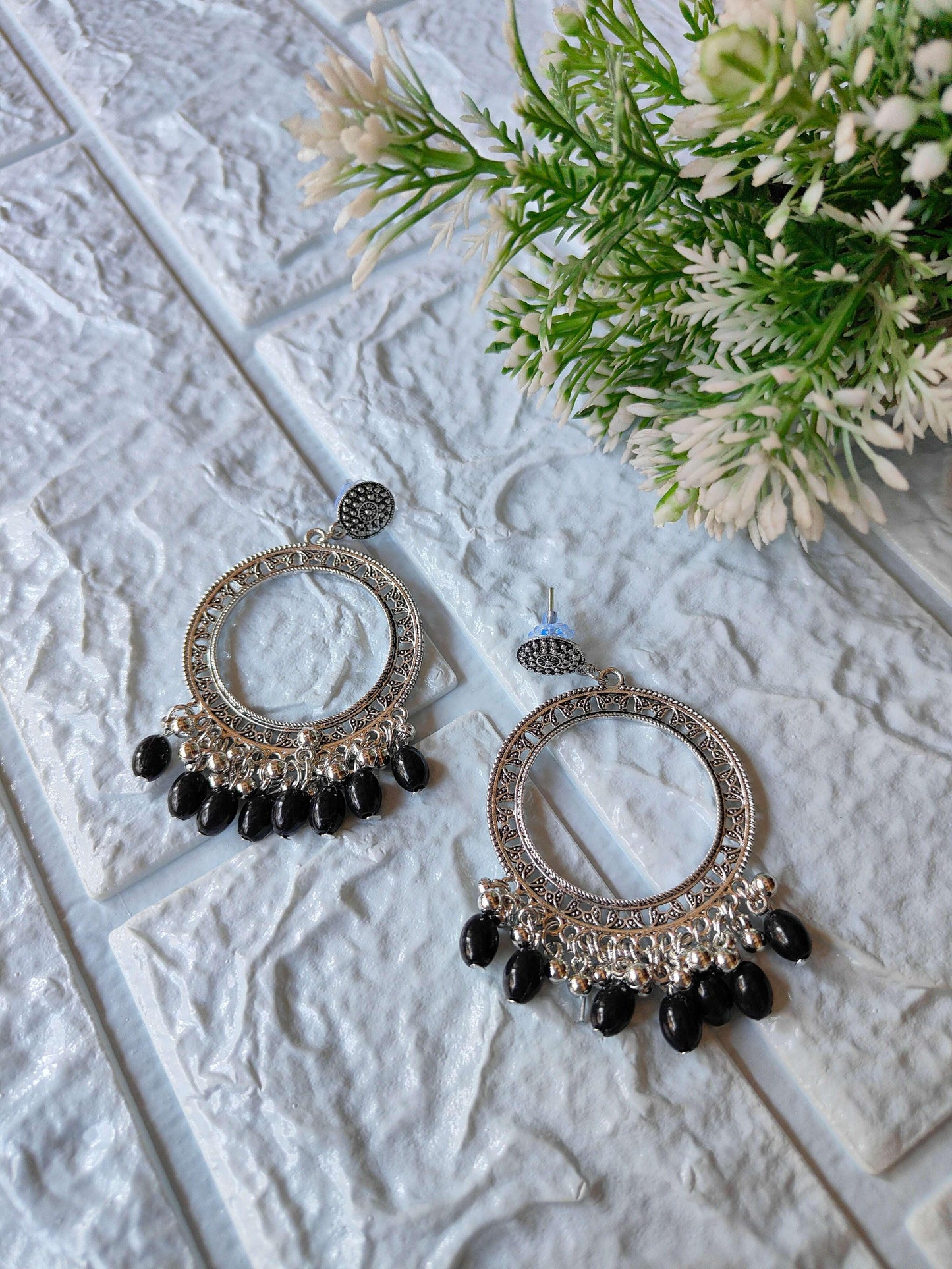 Silver jhumka studs with ornate circular frame and black bead fringe drops