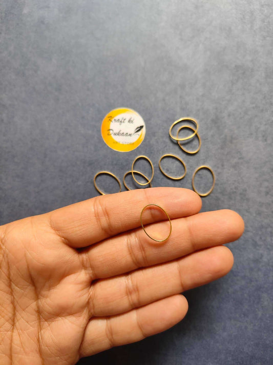 Gold-tone oval bezel ring held in hand; small set of oval bezel rings nearby.