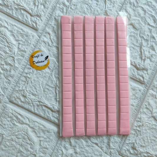 Sticky tack adhesive strips, pink pads on backing sheet