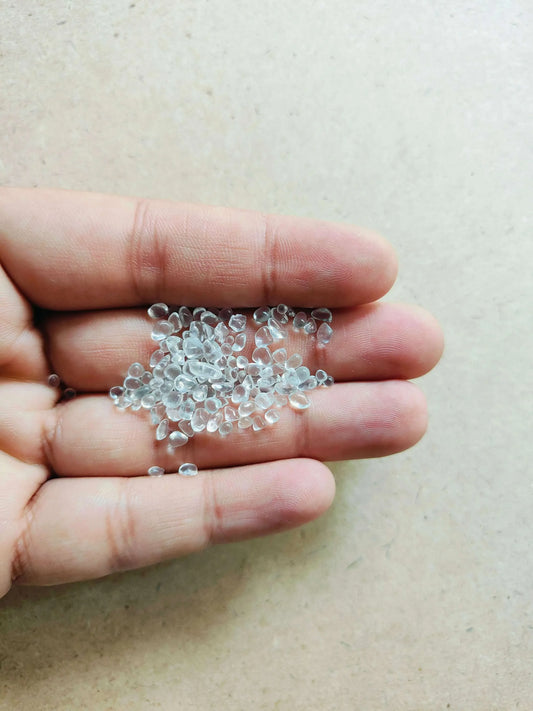Hand holding transparent glass crystals for crafts, perfect for DIY projects and creative designs
