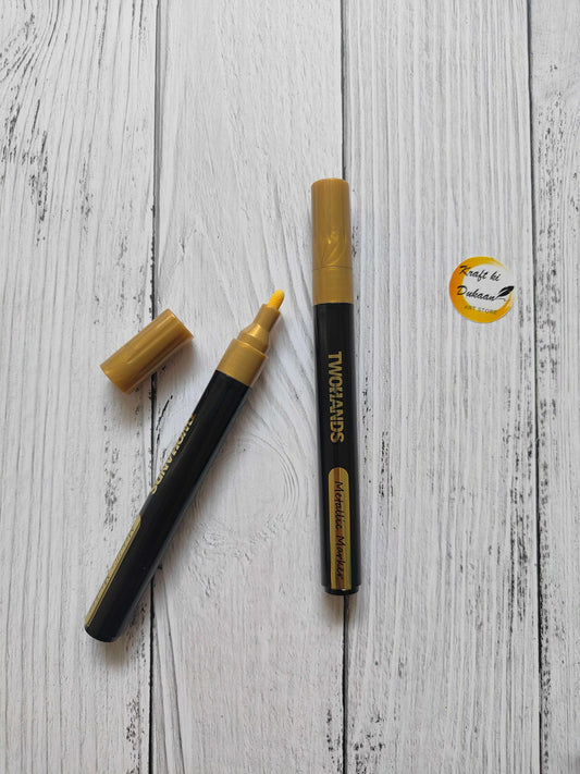 Metallic paint marker, gold color with black body and gold cap.