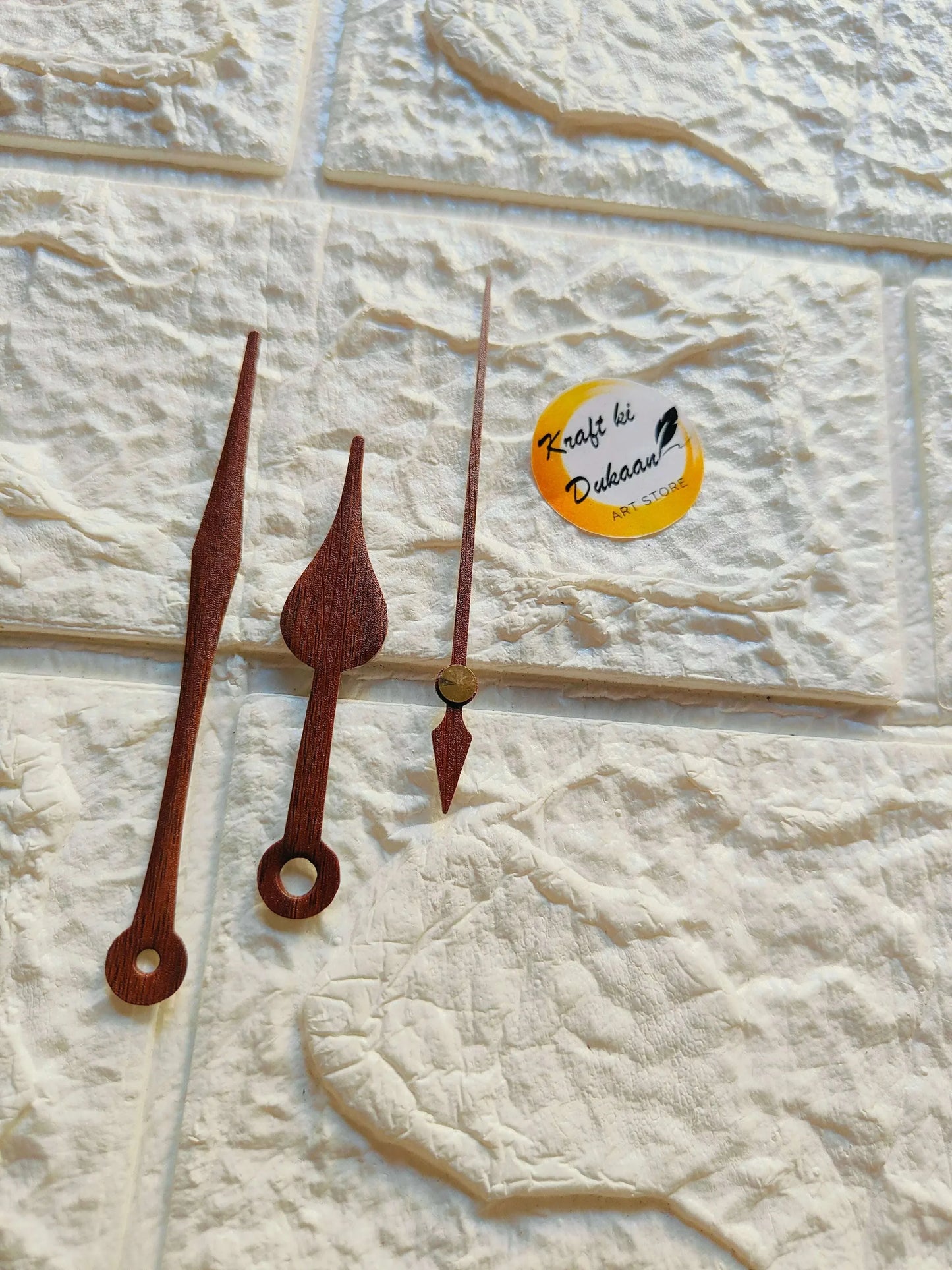 Wood clock hands set: long and teardrop minute/hour with circular cutouts, red-brown.