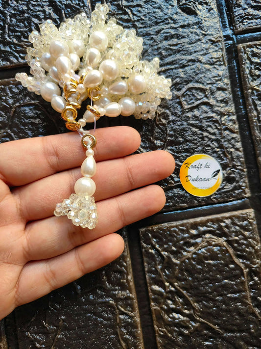 Pearl drop latkan with gold ring and crystal clusters, shown with hand