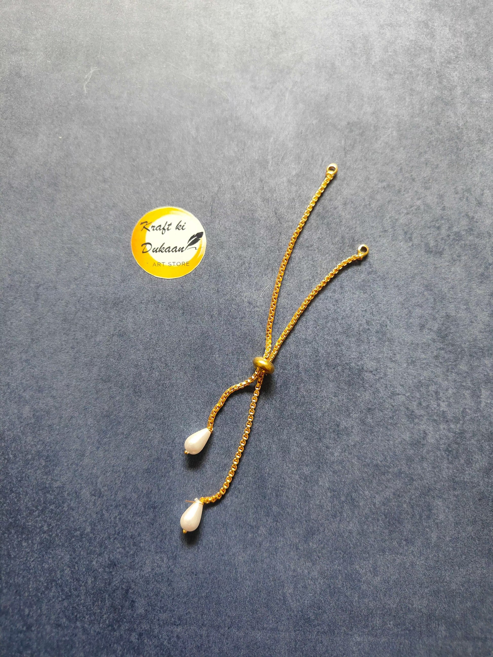 Gold-toned rakhi bracelet chain with two white pearl-like drops and small bead links
