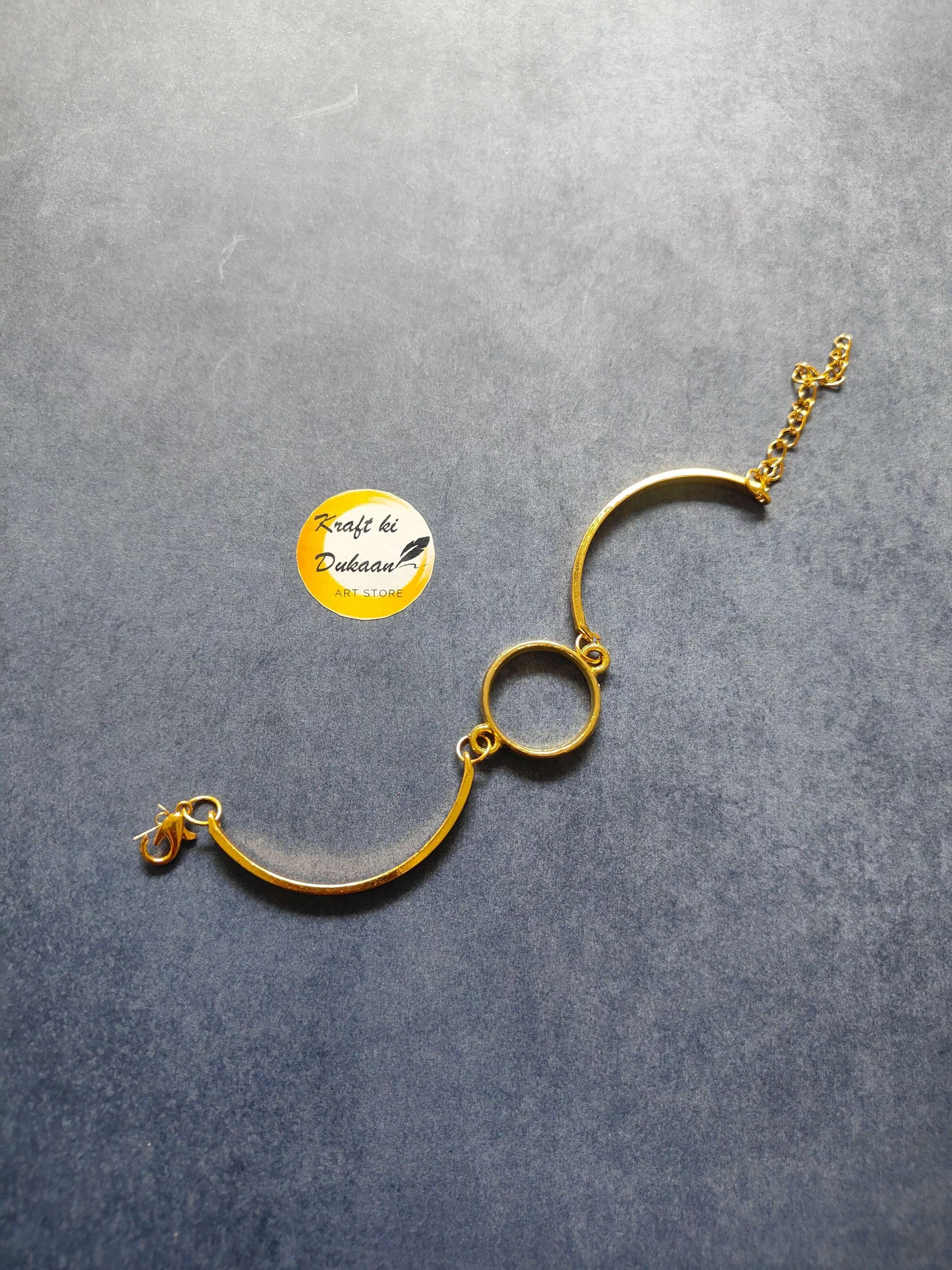 Gold-tone metal round bracelet with circular center link and lobster clasp
