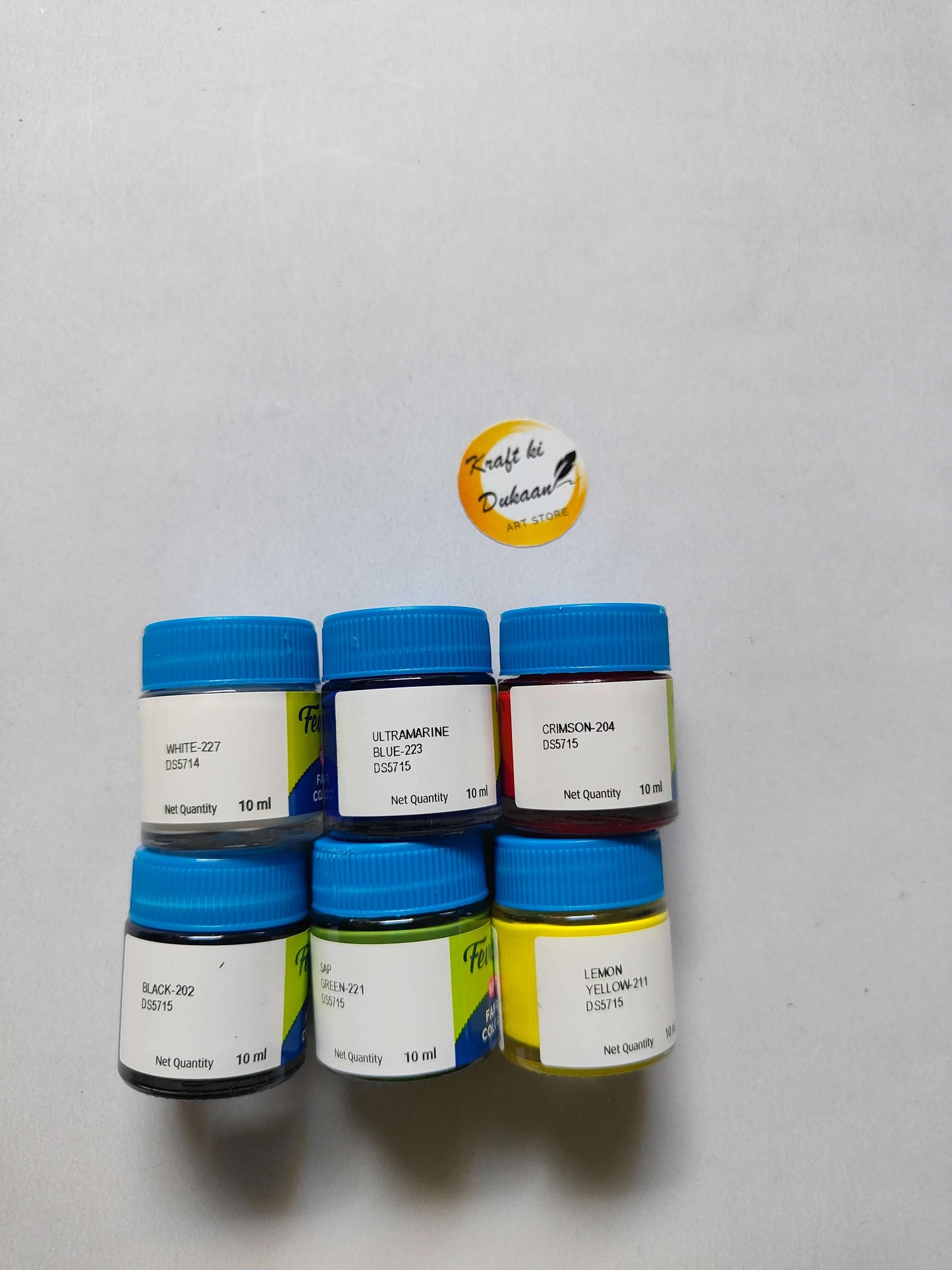 6 fabric paint bottles with blue caps and shade labels: white, ultramarine, crimson, green