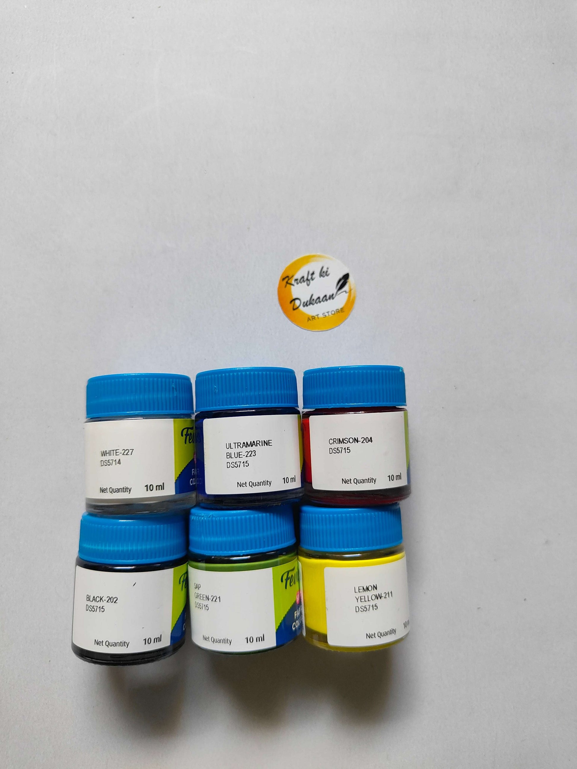 6 fabric paint bottles with blue caps and shade labels: white, ultramarine, crimson, green