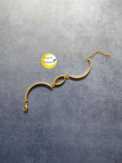 Gold metal oval bracelet with two oval links and small charm at chain end