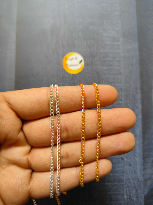 Jewellery Chain: silver and gold curb-link chain bracelets on fingers