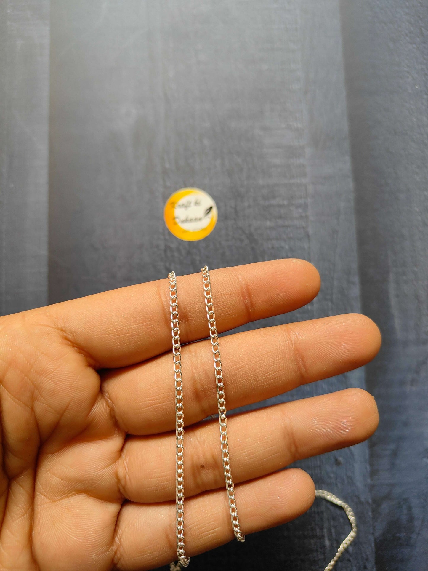Jewellery Chain: silver curb-link chain bracelets on fingers