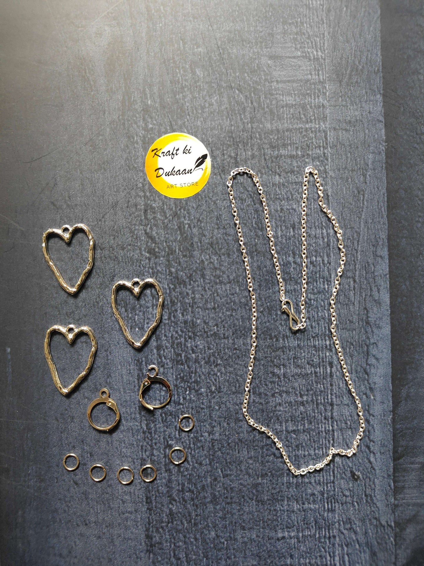 Silver heart stud earrings, small hoop accents, and long necklace chain with links