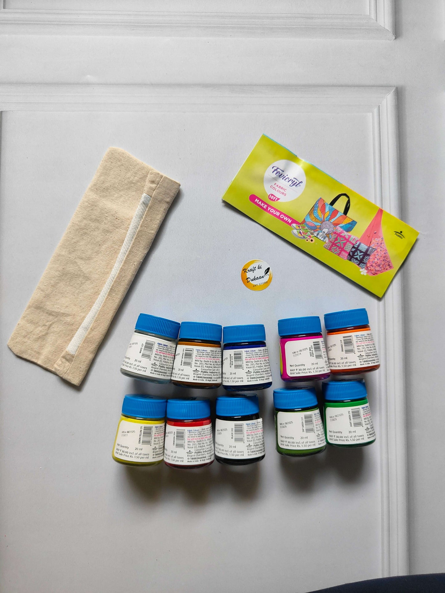 Fabric colours kit: beige pouch and 10 small bottles with blue caps in rows