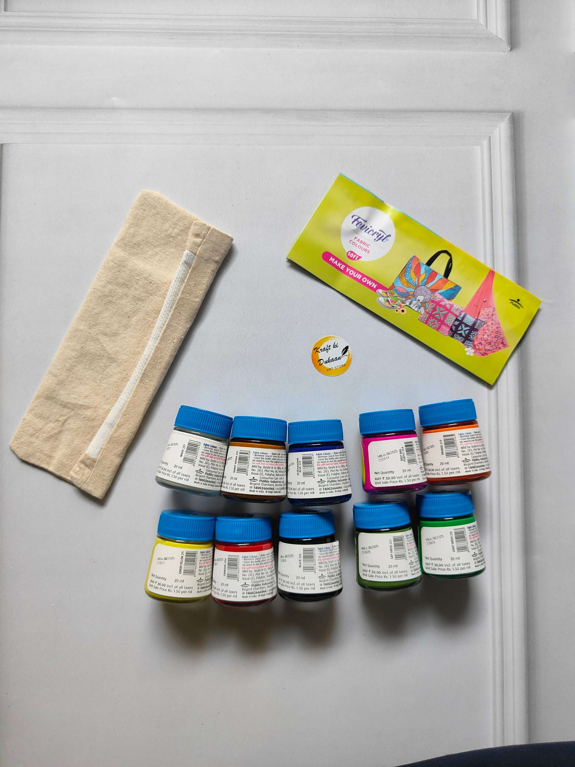 Fabric colours kit: beige pouch and 10 small bottles with blue caps in rows