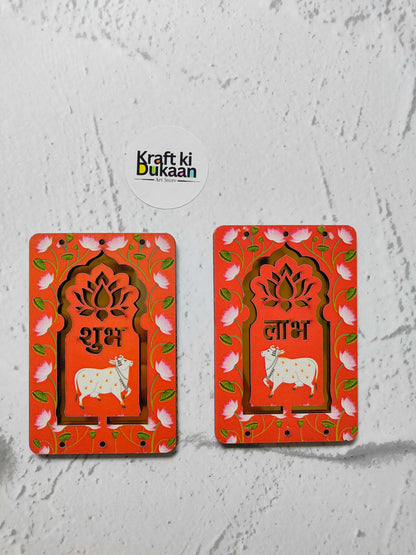 लाल Pichhwai Cow Jharokha मध्यम जोड़ी—फूलदार फ्रेम, गाय, शुभ और लाभ