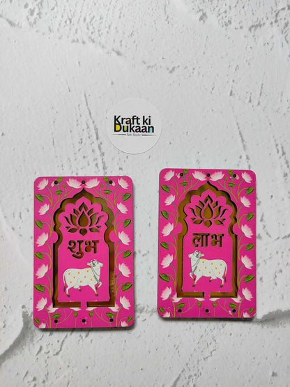 गुलाबी Pichhwai Cow Jharokha मध्यम जोड़ी—फूलदार फ्रेम, गाय, शुभ/लाभ