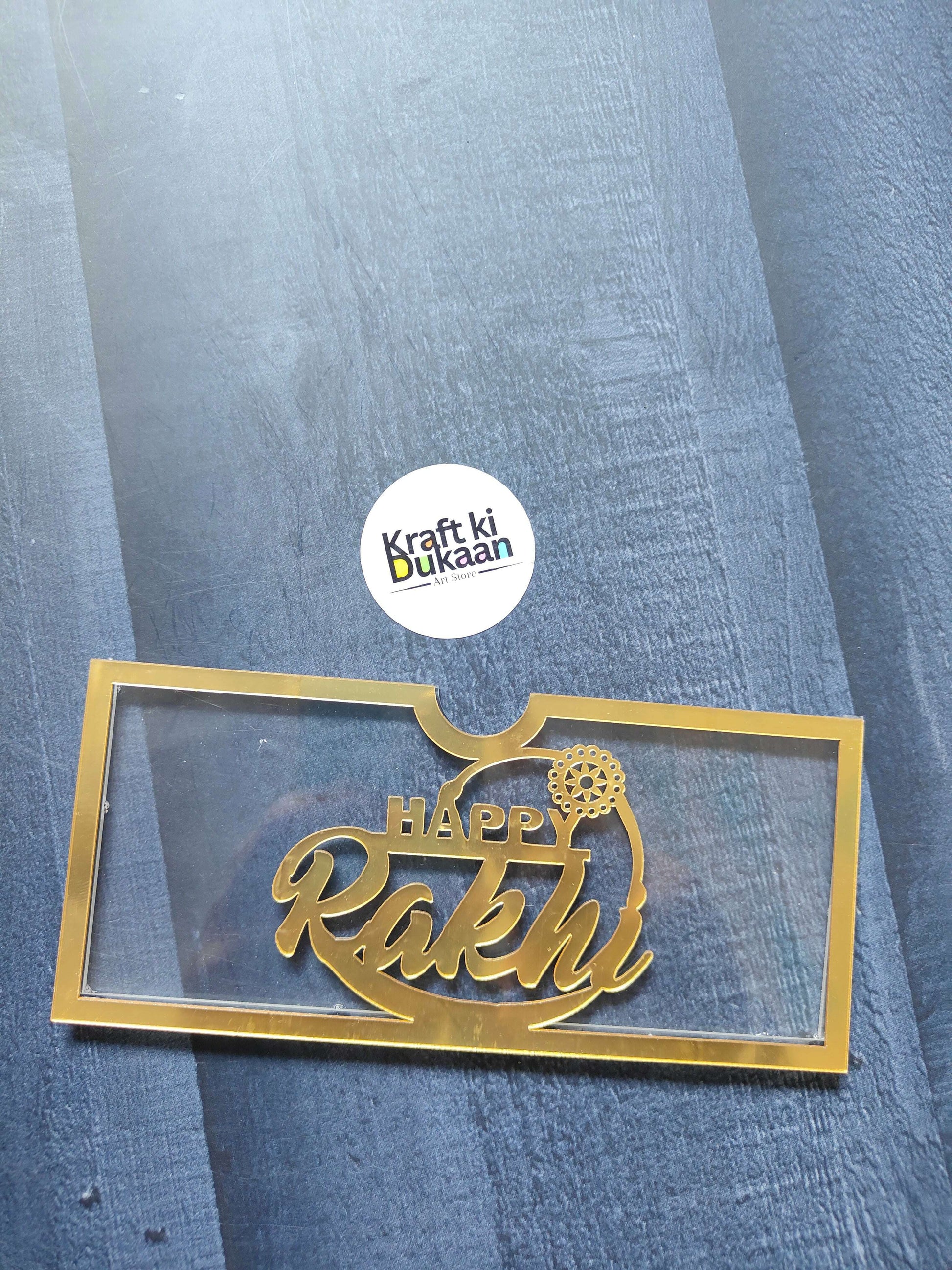 Acrylic Golden Rakhi envelope with gold border and Happy Rakhi text