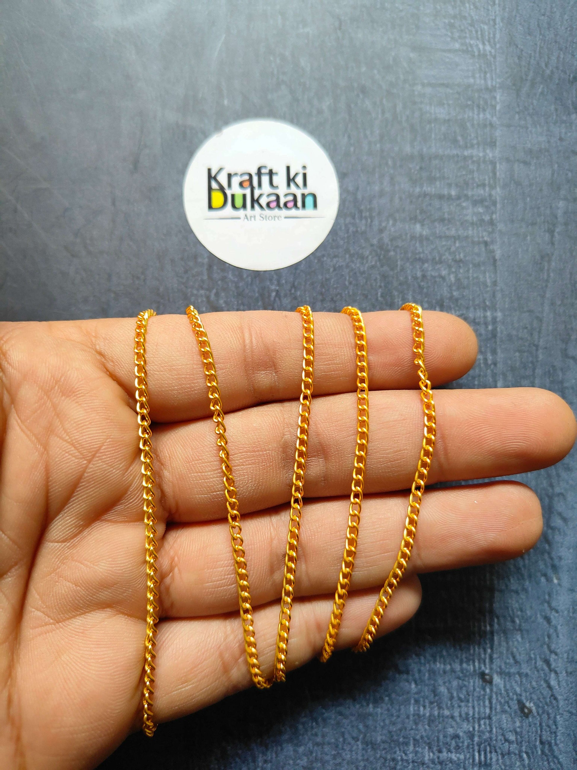 Jewellery Chain: multiple gold curb-link chain bracelets on fingers