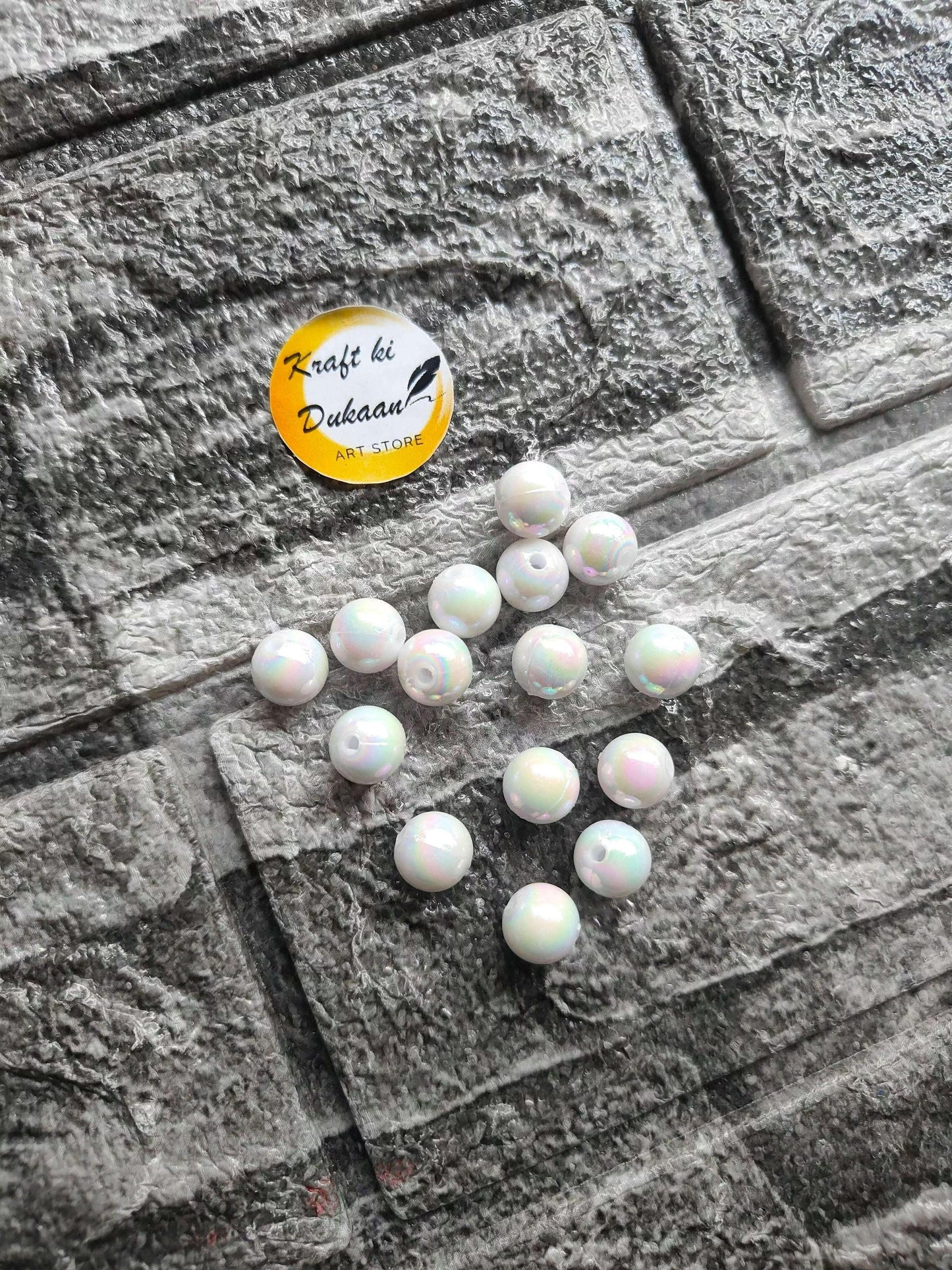ABS rainbow white beads, scattered round beads on grey fabric surface