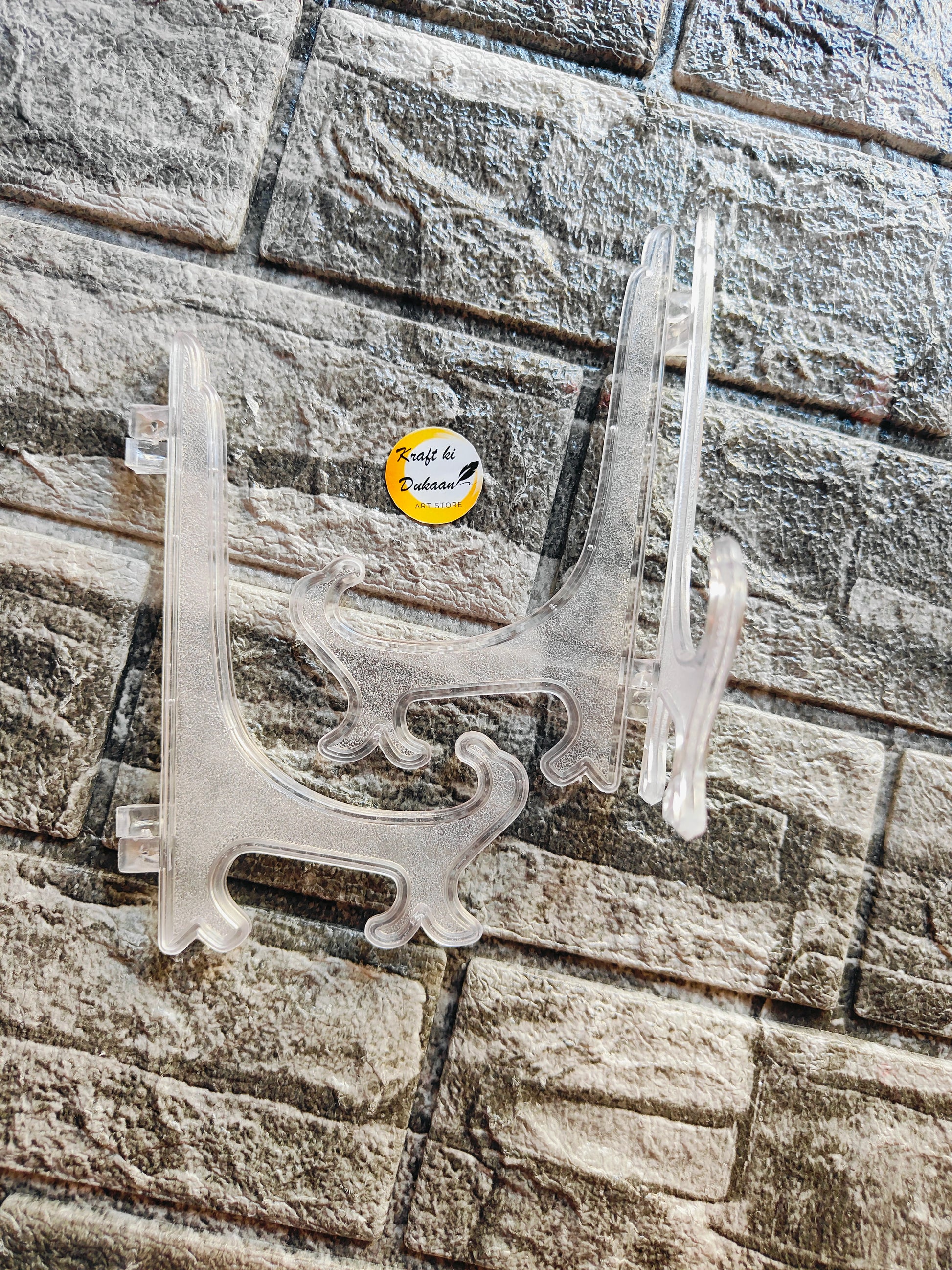 Clear acrylic display stand designed for showcasing artwork and collectibles on a flat surface
