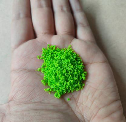 Bright green artificial moss for resin art displayed in a hand, ideal for creative projects