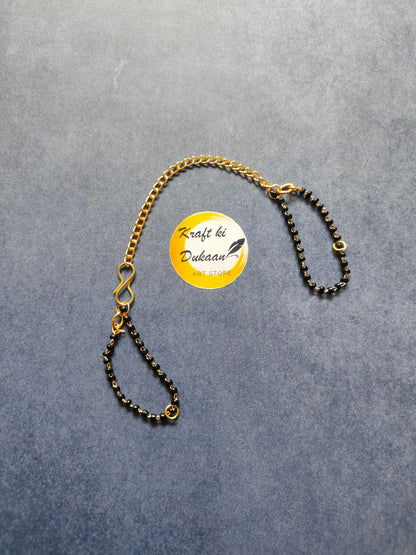 Rakhi bracelet chain with gold-tone and black bead links, adjustable loop clasp