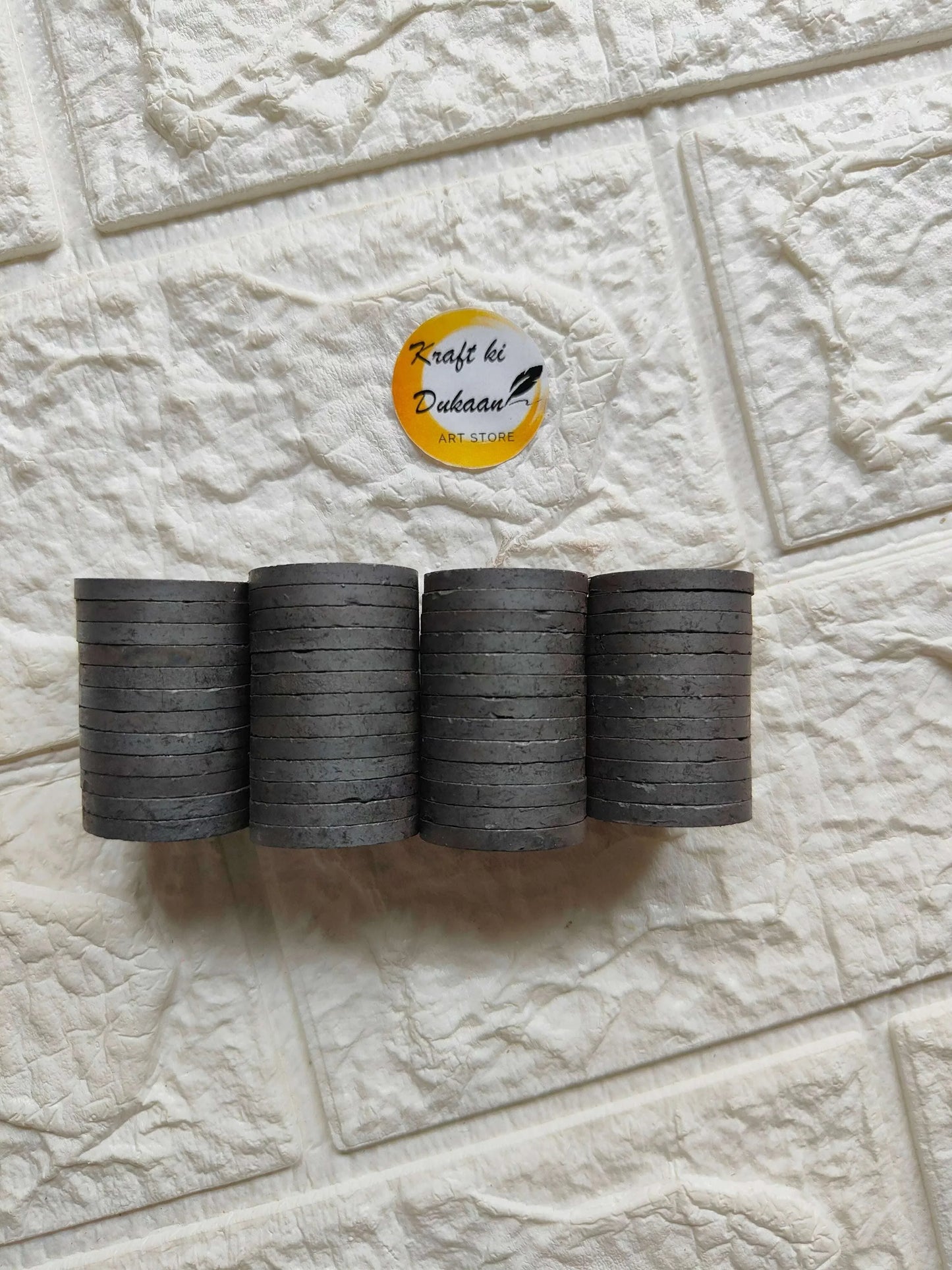 Set of black round magnets, stacked discs in multiple rolls