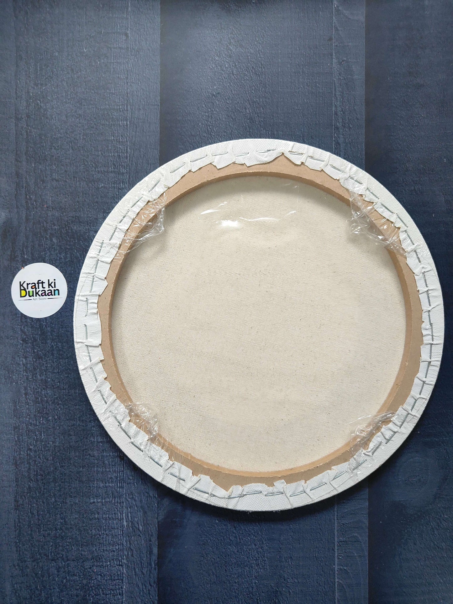 Round stretched canvas board with frame, back view with stapled rim and backing