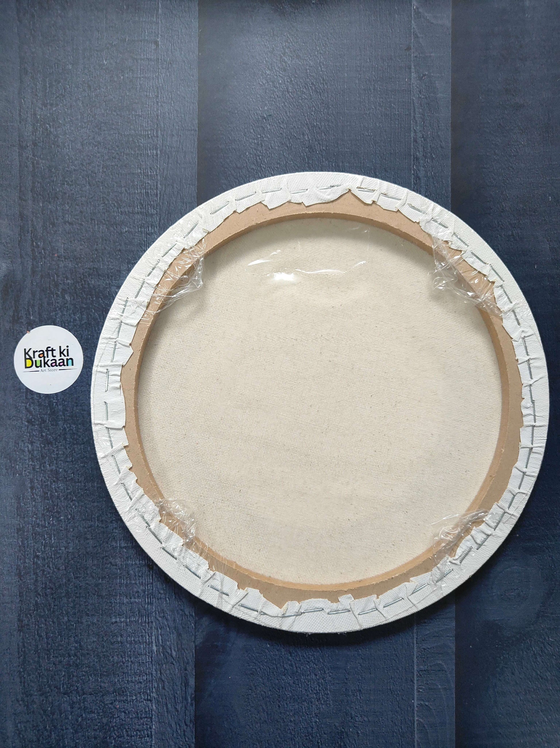 Round stretched canvas board with frame, back view with stapled rim and backing