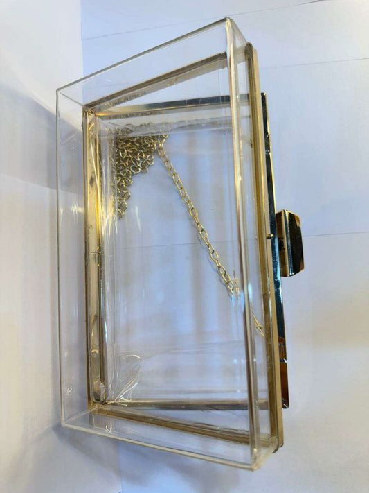 Acrylic clutch bag with gold frame, gold chain strap, and open front