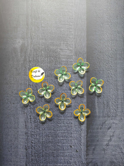 Light green flower beads with yellow edging, scattered on surface