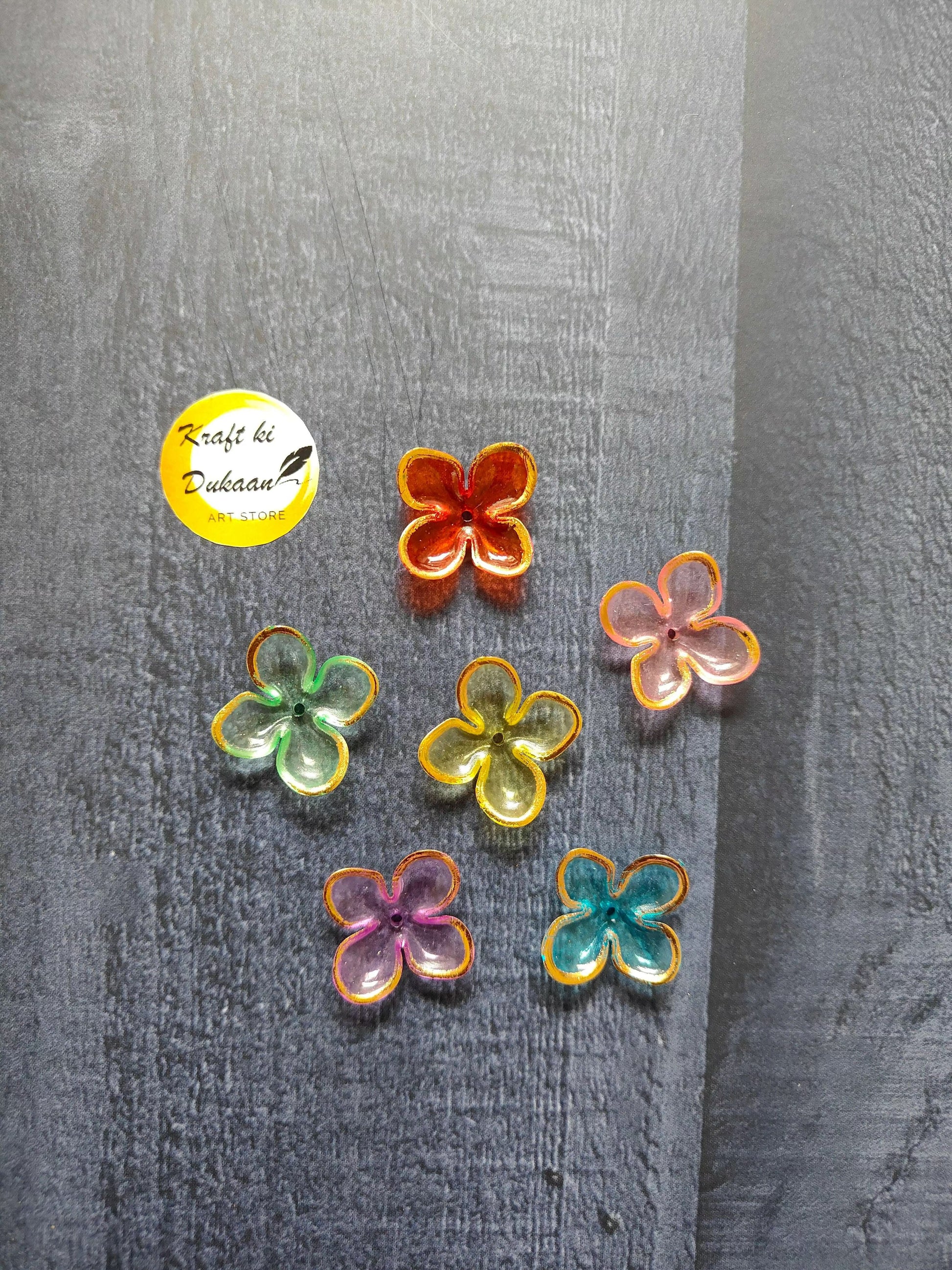 Flower-shaped bead charms in red, green, orange, and pink with yellow borders
