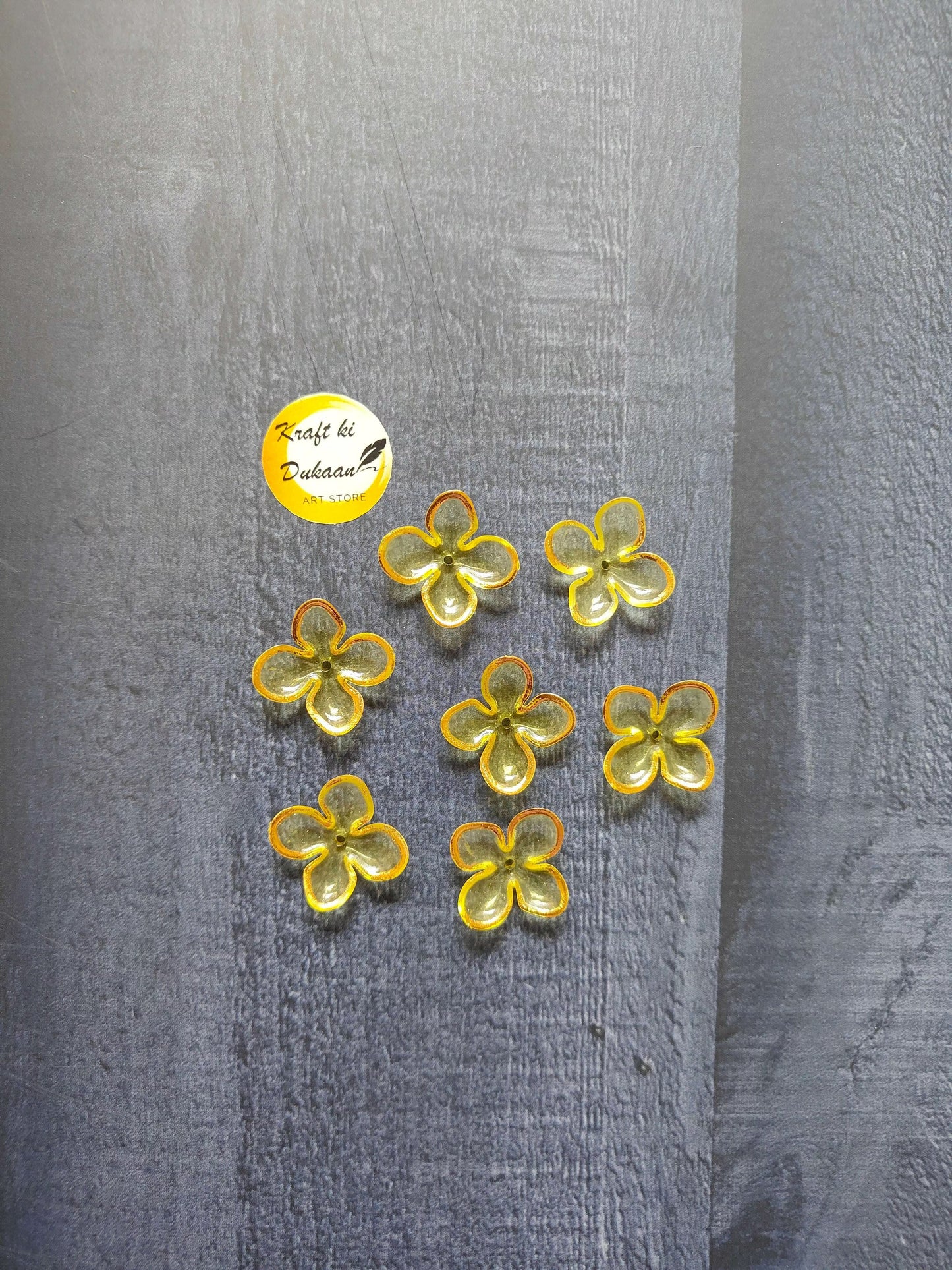 Yellow flower beads with orange edging, scattered on surface