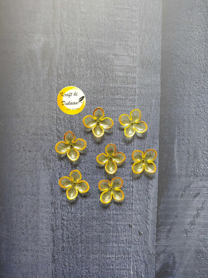 Yellow flower beads with orange edging, scattered on surface