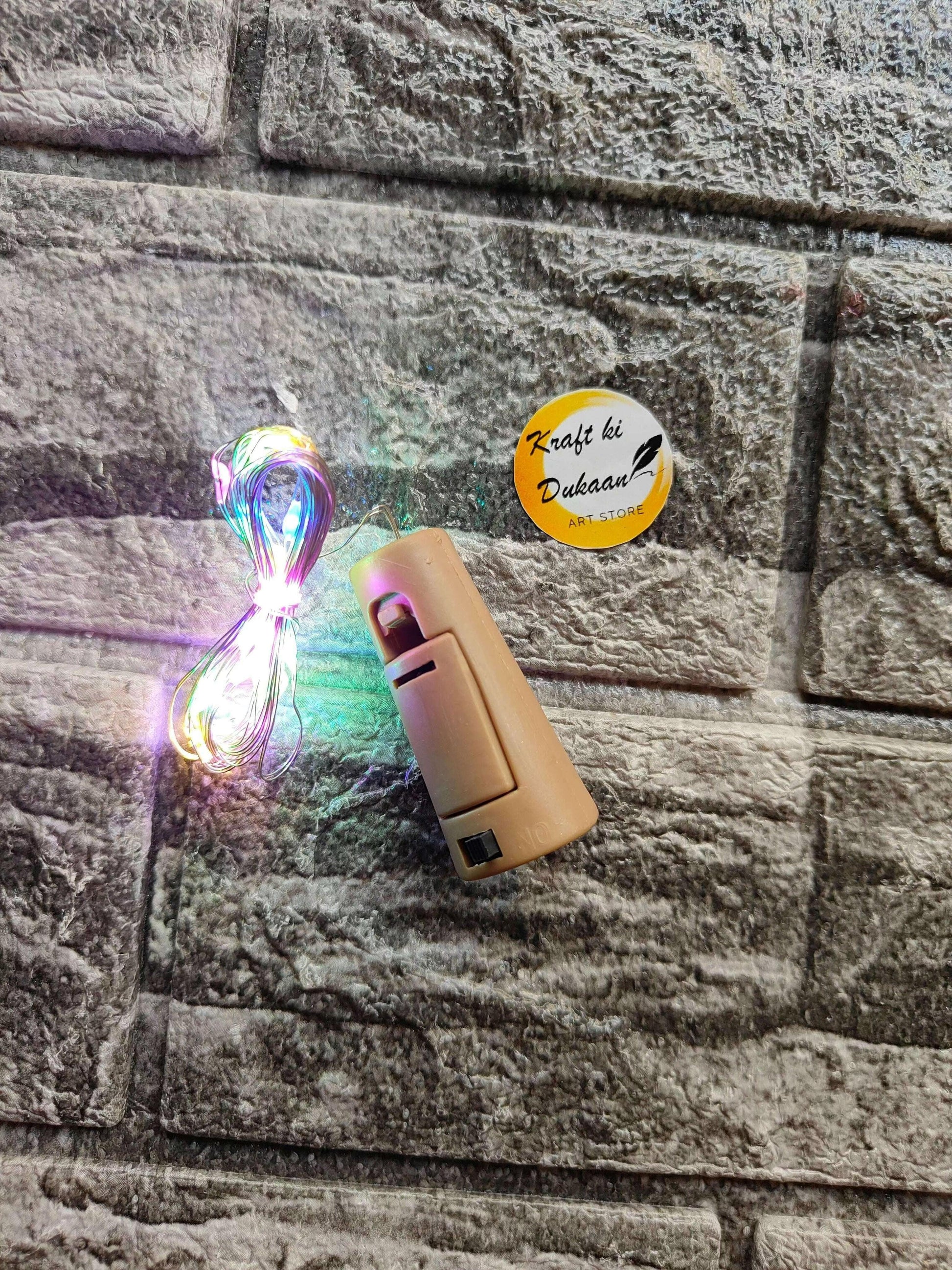 Cork Light Multi—beige light capsule with braided cord, front button slots visible