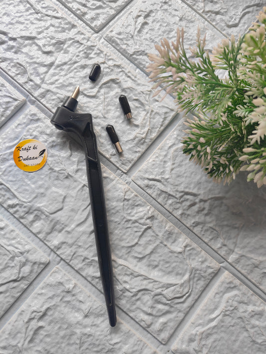 Black 360-degree rotating cutting tool with interchangeable tips on textured gray surface near green plant