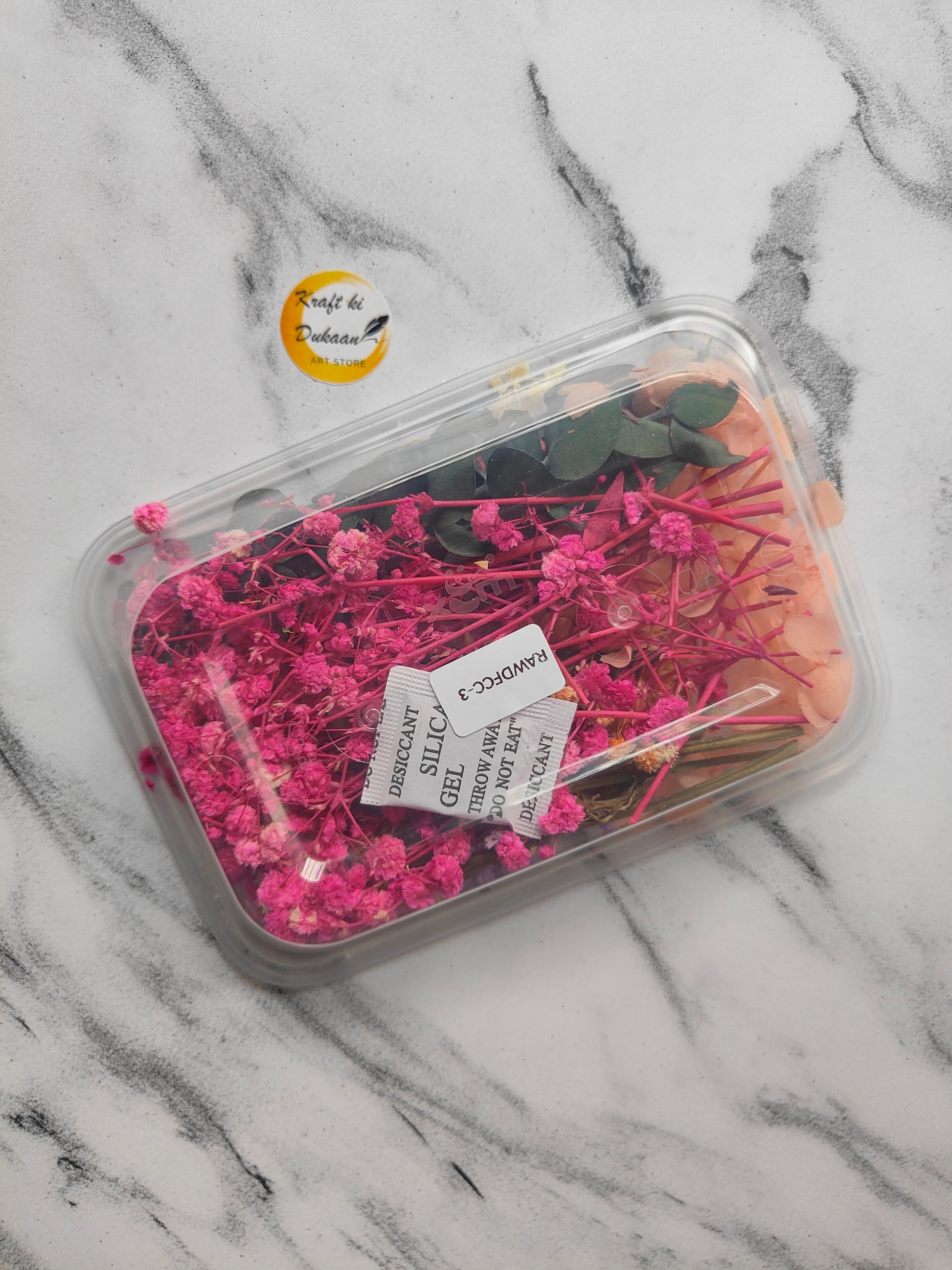 Assorted dried flowers for craft projects in a clear plastic container with various colors and types