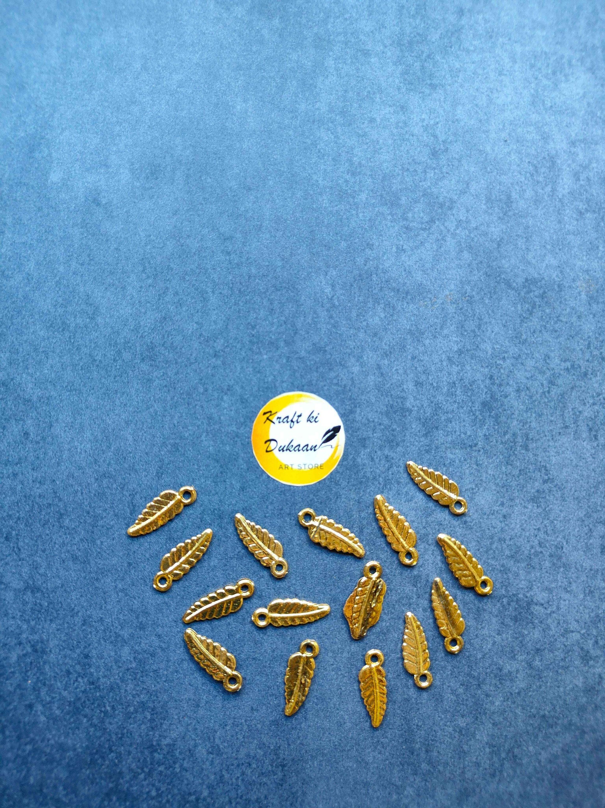 Gold-toned leaf-shaped plastic charms with loop, pack of 100