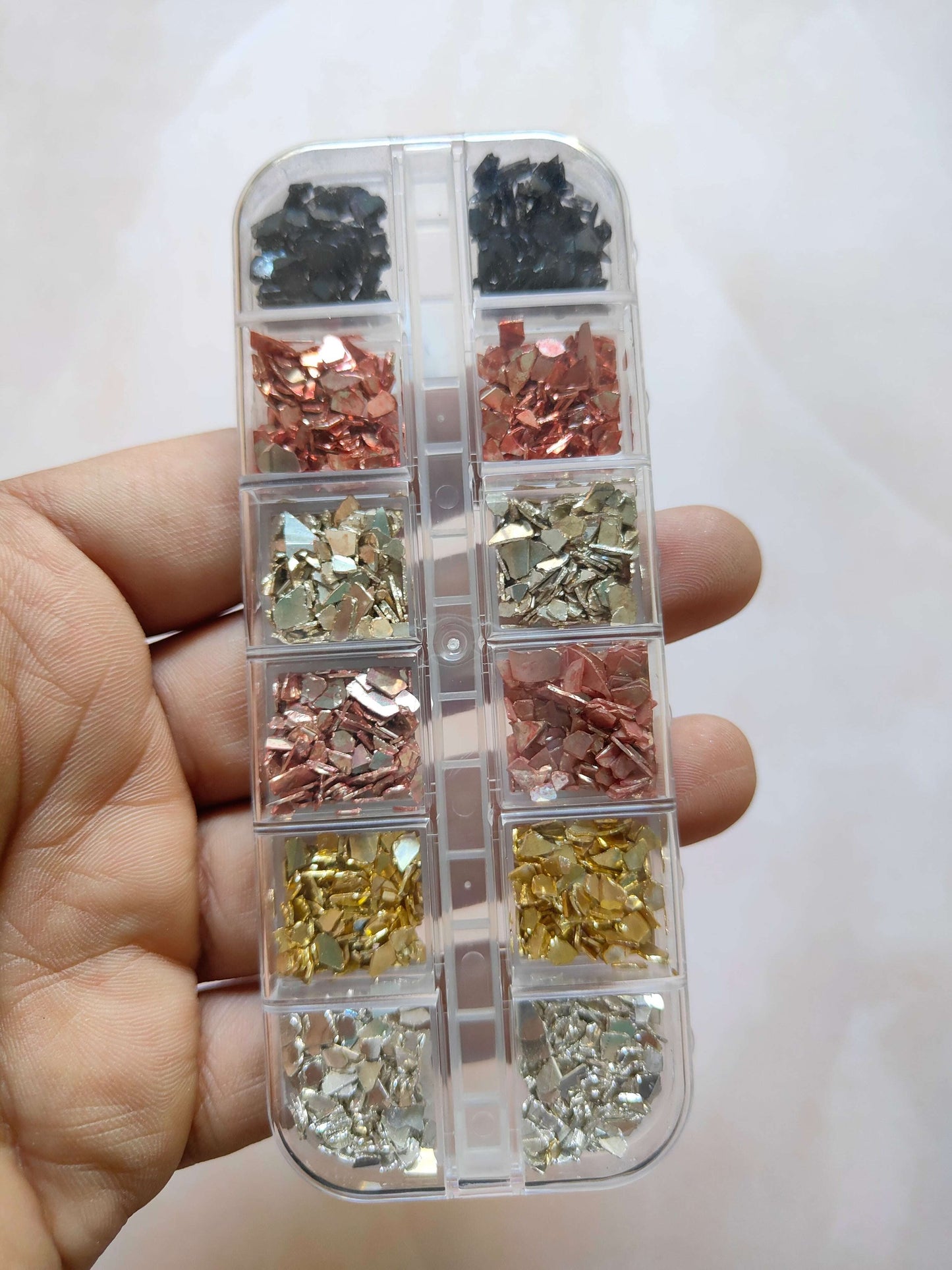 Stone crystal chips in a clear divided case: black, copper, olive, and silver pieces