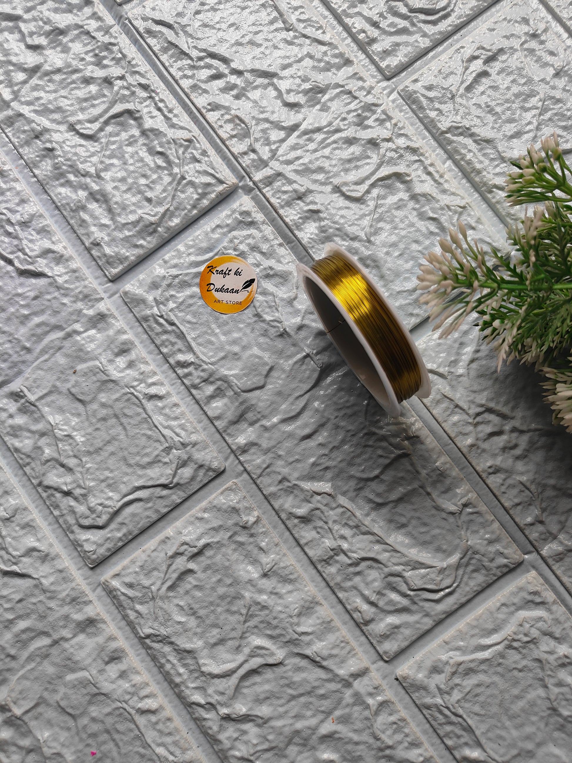 Gold craft wire roll 0.4mm displayed on textured surface for crafting and DIY projects