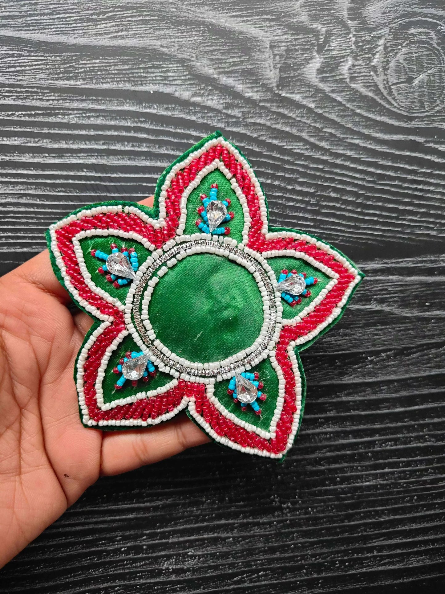 Green decorative patch with oval beaded center, red and white petal edges